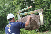 Hardscape Expert using Boulder Grab Attachment to lift large rock