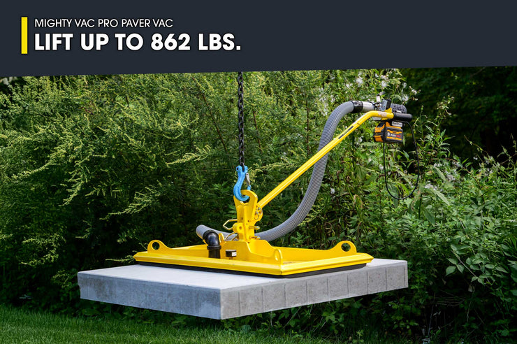 Yellow Mighty Vac Pro Paver Vac on a concrete slab with greenery in the background